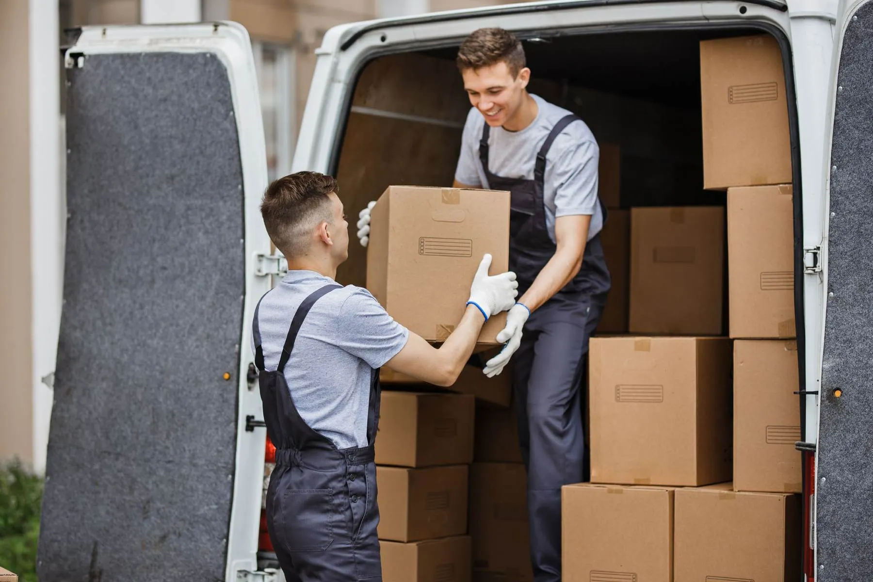 Two delivery workers loading parcels into a van